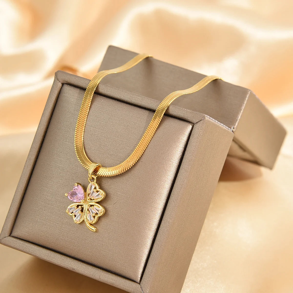 Kaulakoru, jossa nelilehtinen apilan muotoinen onnenamuetti ja zirkoni