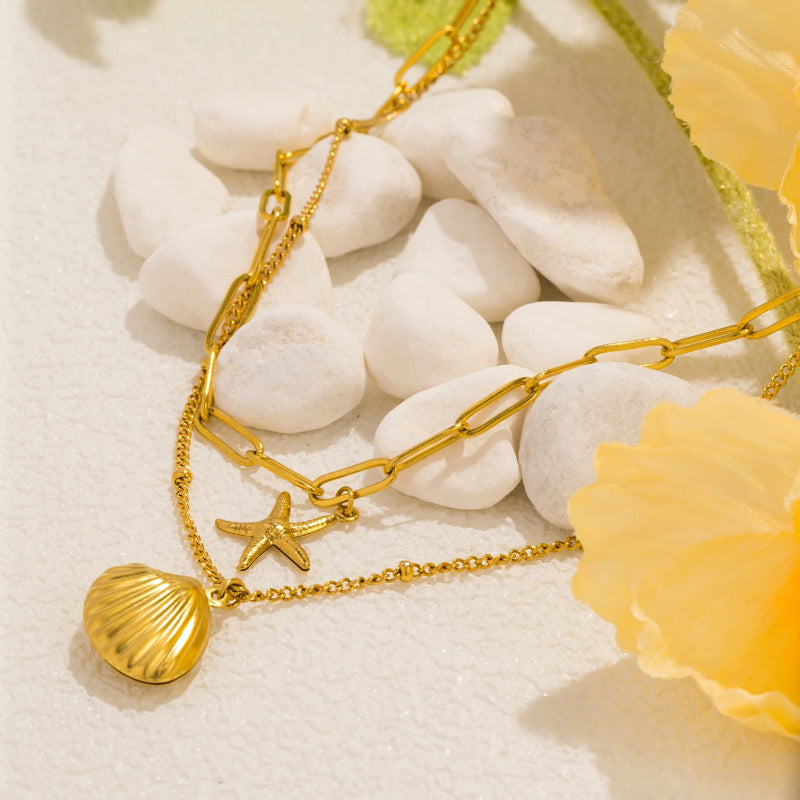 Kaksirivinen kaulakoru, jossa simpukkariipukset, kampasimpukka ja meritähti