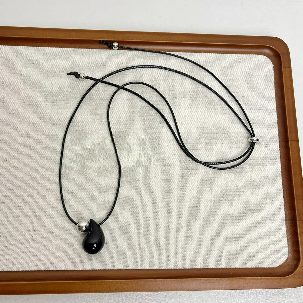 Musta vesipisara-riipus nauhakaulakoru