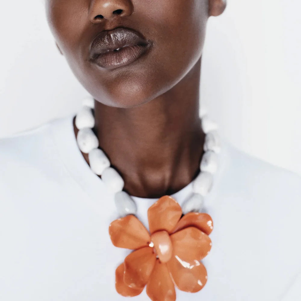 Kaulakoru, jossa suuri oranssi kukkariipus