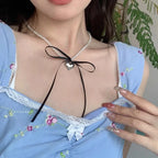 Kaulakoru sydänriipuksella ja mustilla helmillä