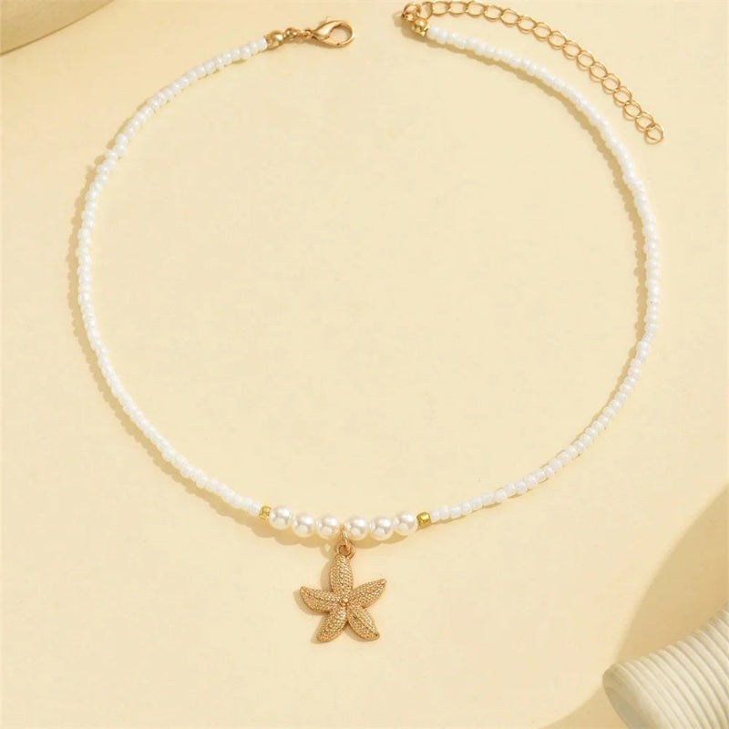 Kaulakoru, jossa on meritähtiriipus ja simpukankuori