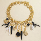 Choker-kaulakoru, jossa on koralliriipuksia ja simpukoita