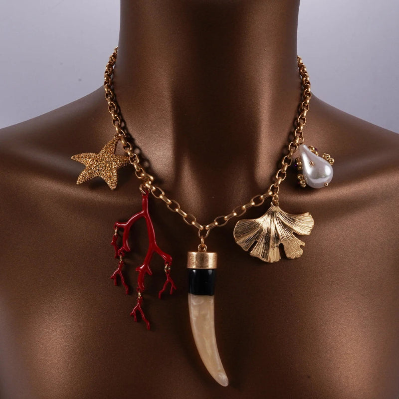 Kaulakoru, jossa on koralliriipukset ja simpukoita