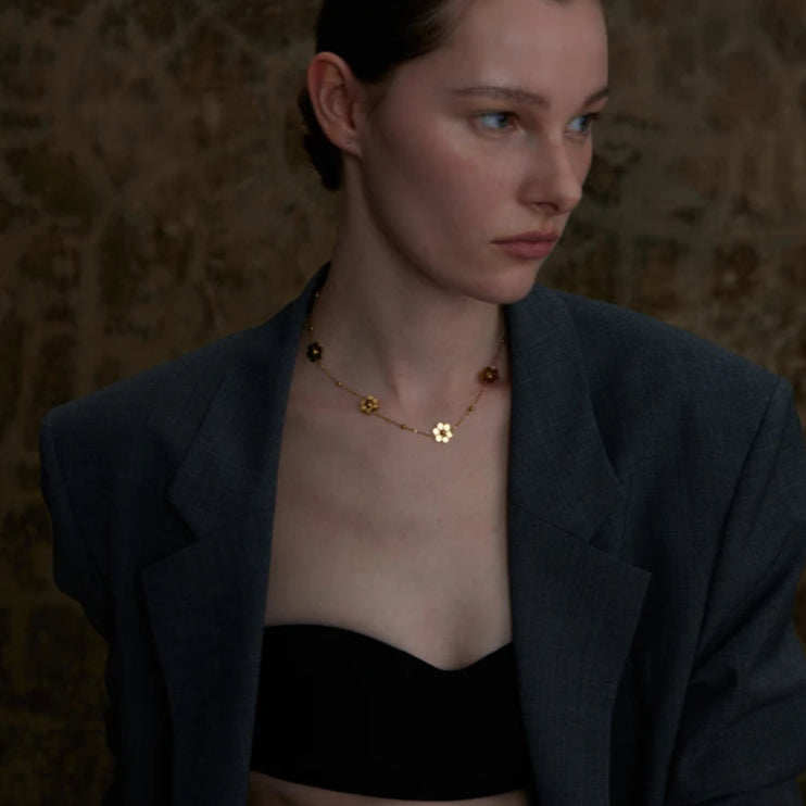 Kaulakoru kaulalle, jossa on kultaiset kukka-riipukset