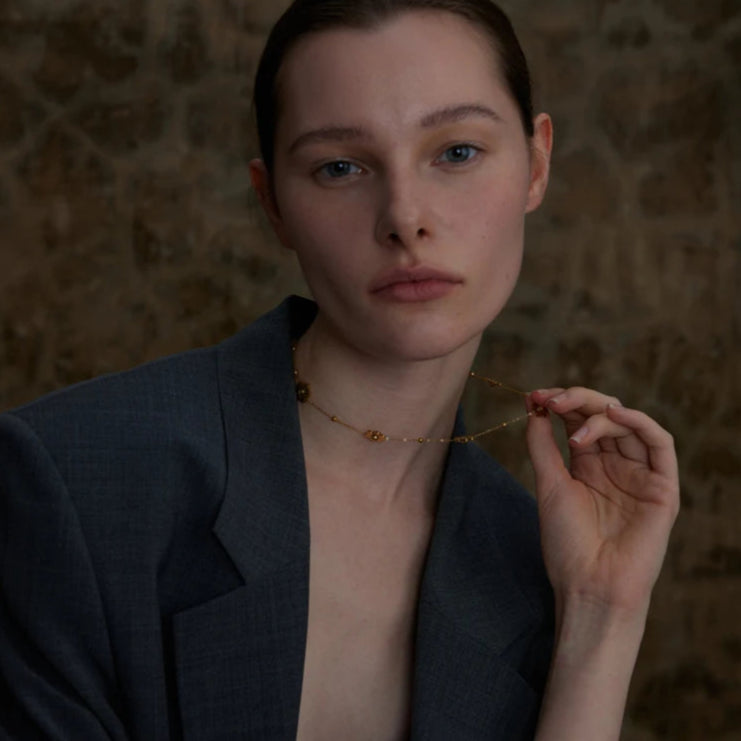 Kaulakoru kaulalle, jossa on kultaiset kukka-riipukset