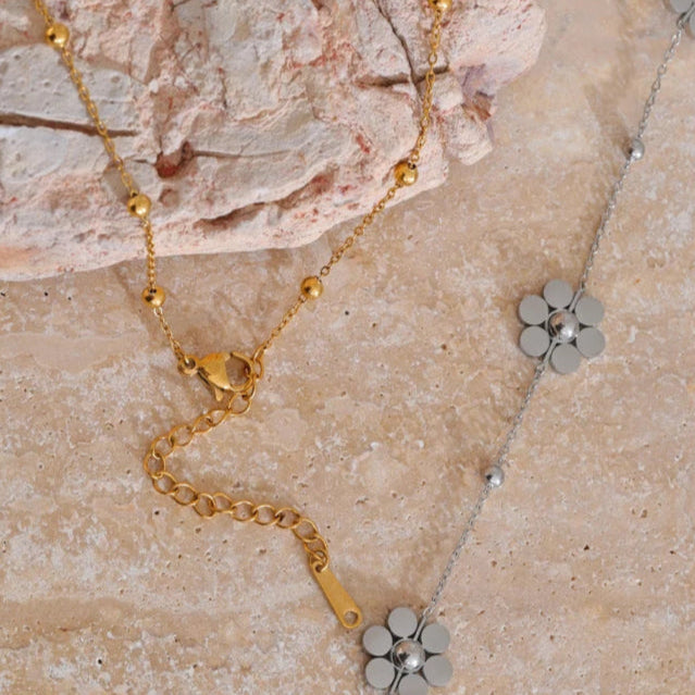 Kaulakoru kaulalle, jossa on hopeiset kukka-riipukset