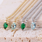 Söpö kaulakoru, jossa on vesipisaran muotoinen riipus ja kulta- sekä sinisiä zirkoneja