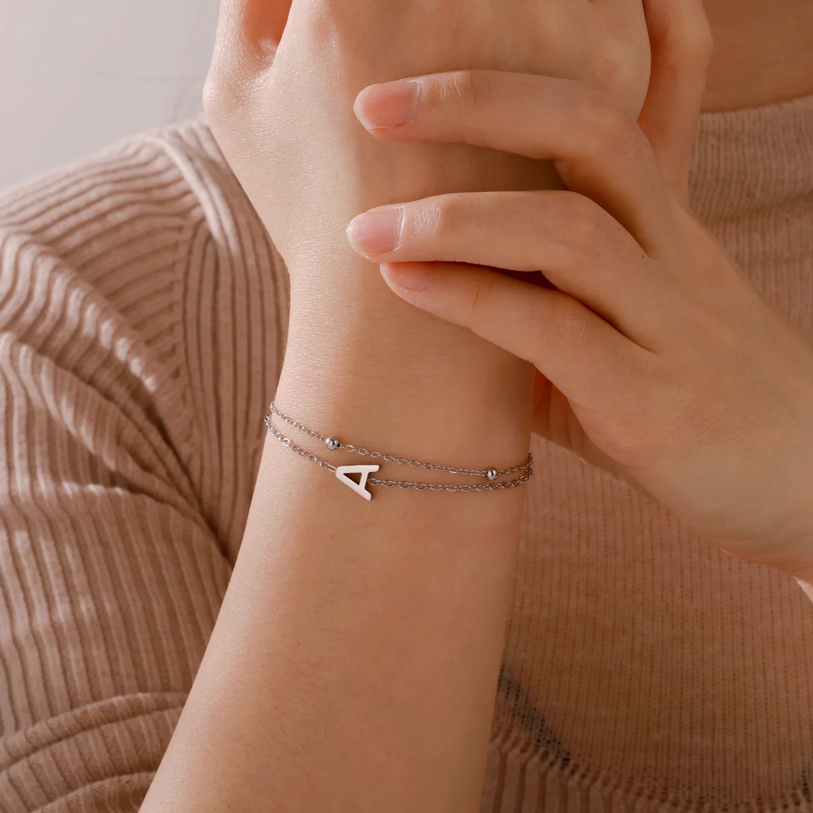 Kaksoisalkukirjainrannekoru kultaa ja hopeaa 