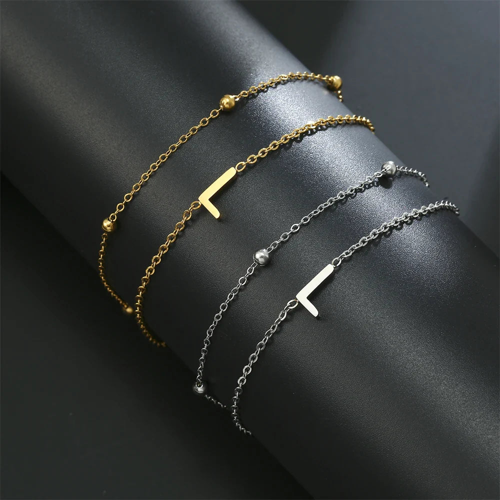 Kaksoisalkukirjainrannekoru kultaa ja hopeaa  l