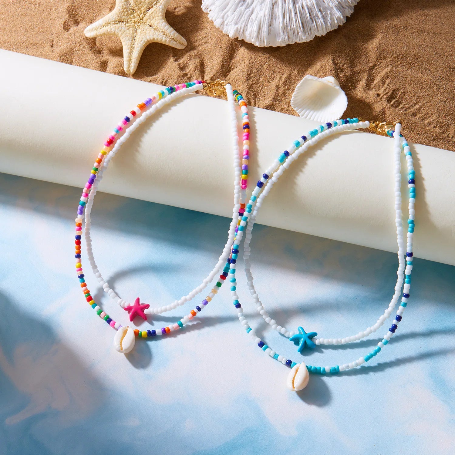 Kaksinkertainen kaulakoru, simpukoita ja värillisiä helmiä, sininen tähti