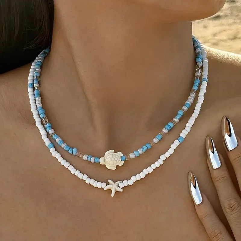 Kaksinkertainen kaulakoru, simpukoita ja värillisiä helmiä, sininen kilpikonna