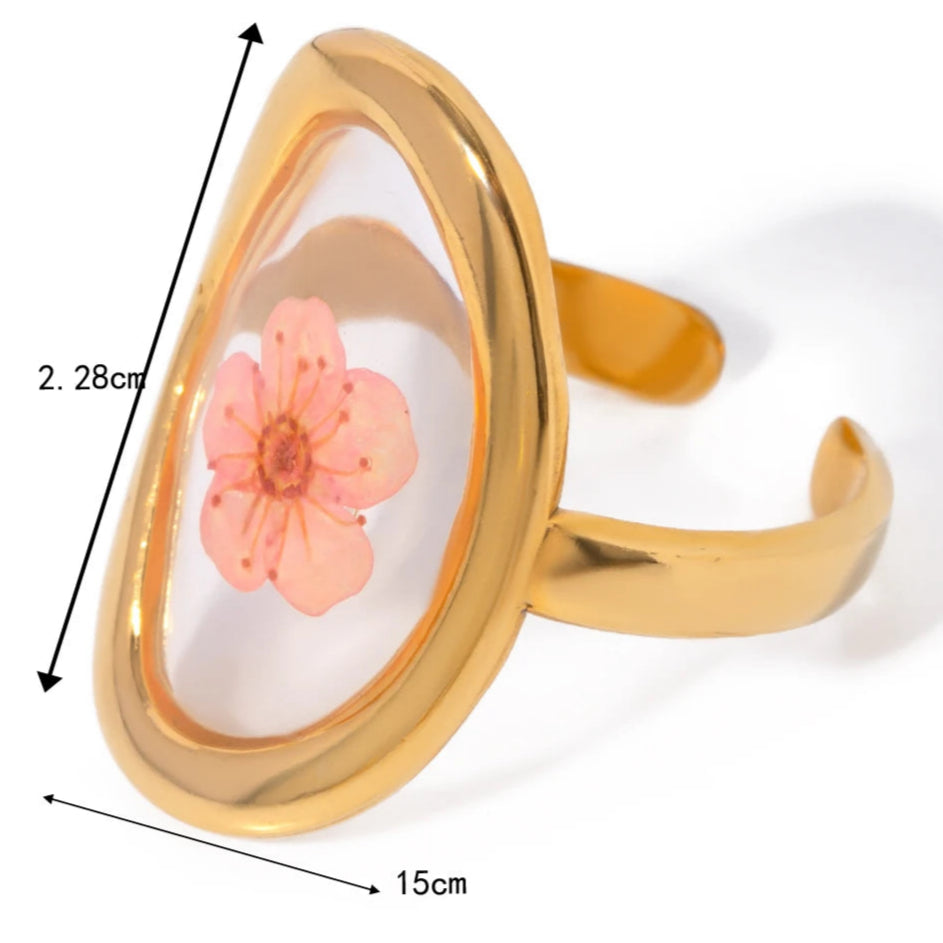 Suuri sormus kukalla läpinäkyvässä kehyksessä