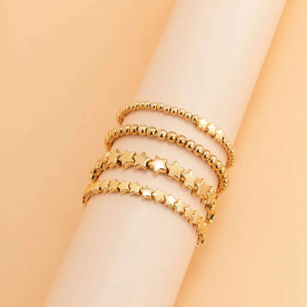 Setti, jossa 4 kultaiset tähtirannekorut