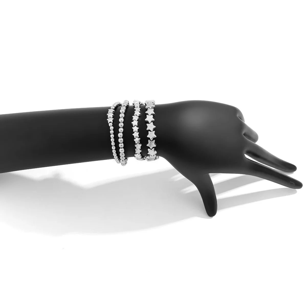 Setti, jossa 4 hopeiset tähtirannekorut