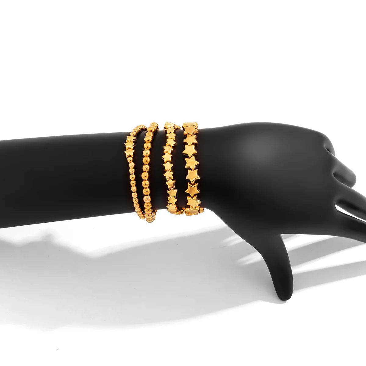 Setti, jossa 4 kultaiset tähtirannekorut